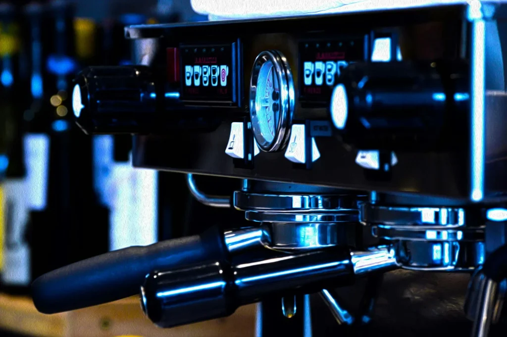 Professional espresso machine with pressure gauge and chrome accents on a dark background