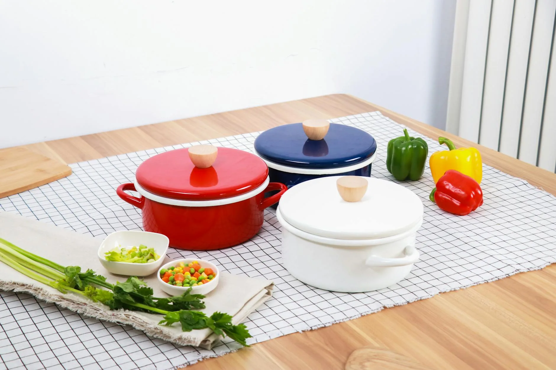Colourful enamel cast iron pots displayed on a kitchen shelf