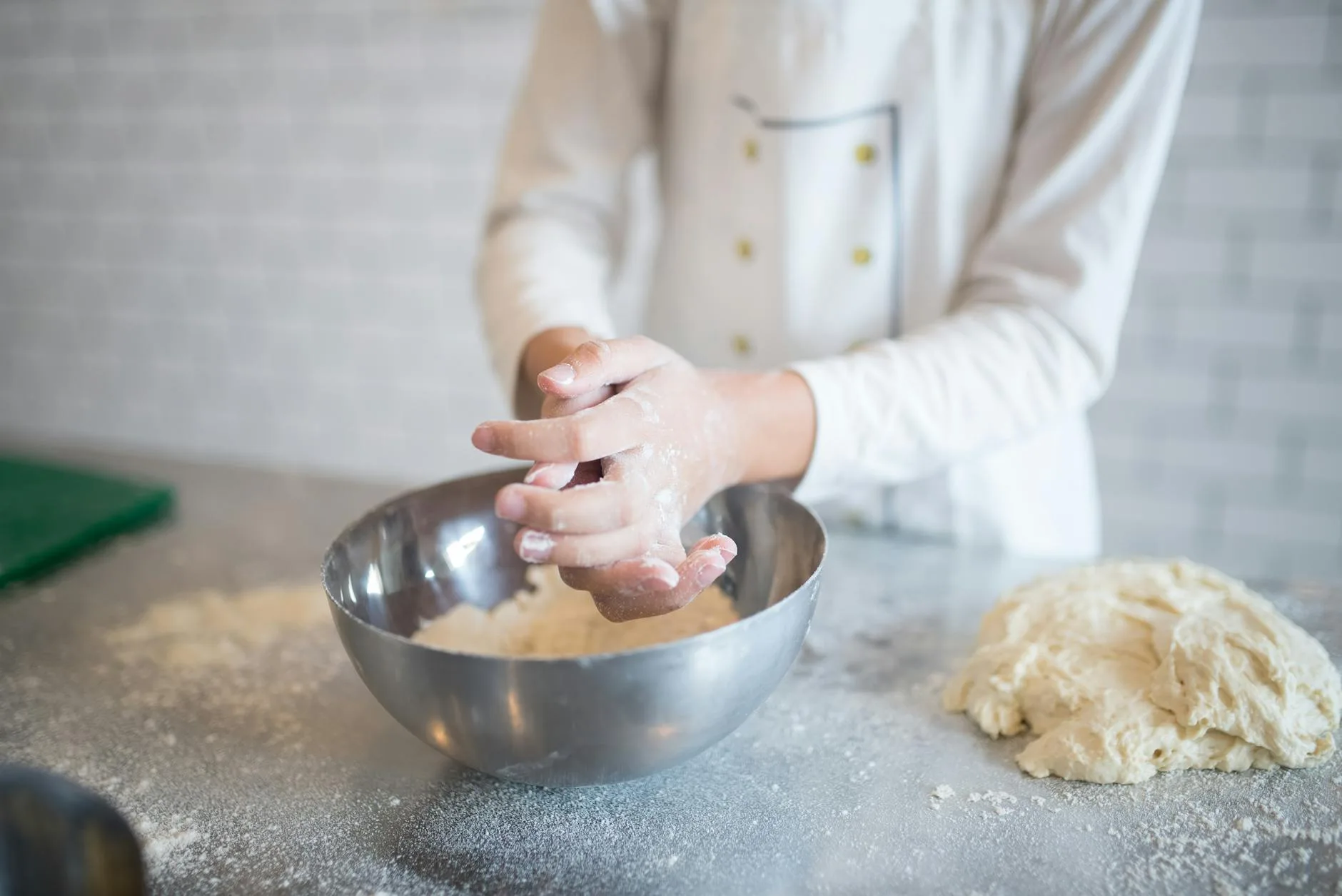 Bread dough being kneaded with a dough hook in a stand mixer bowl