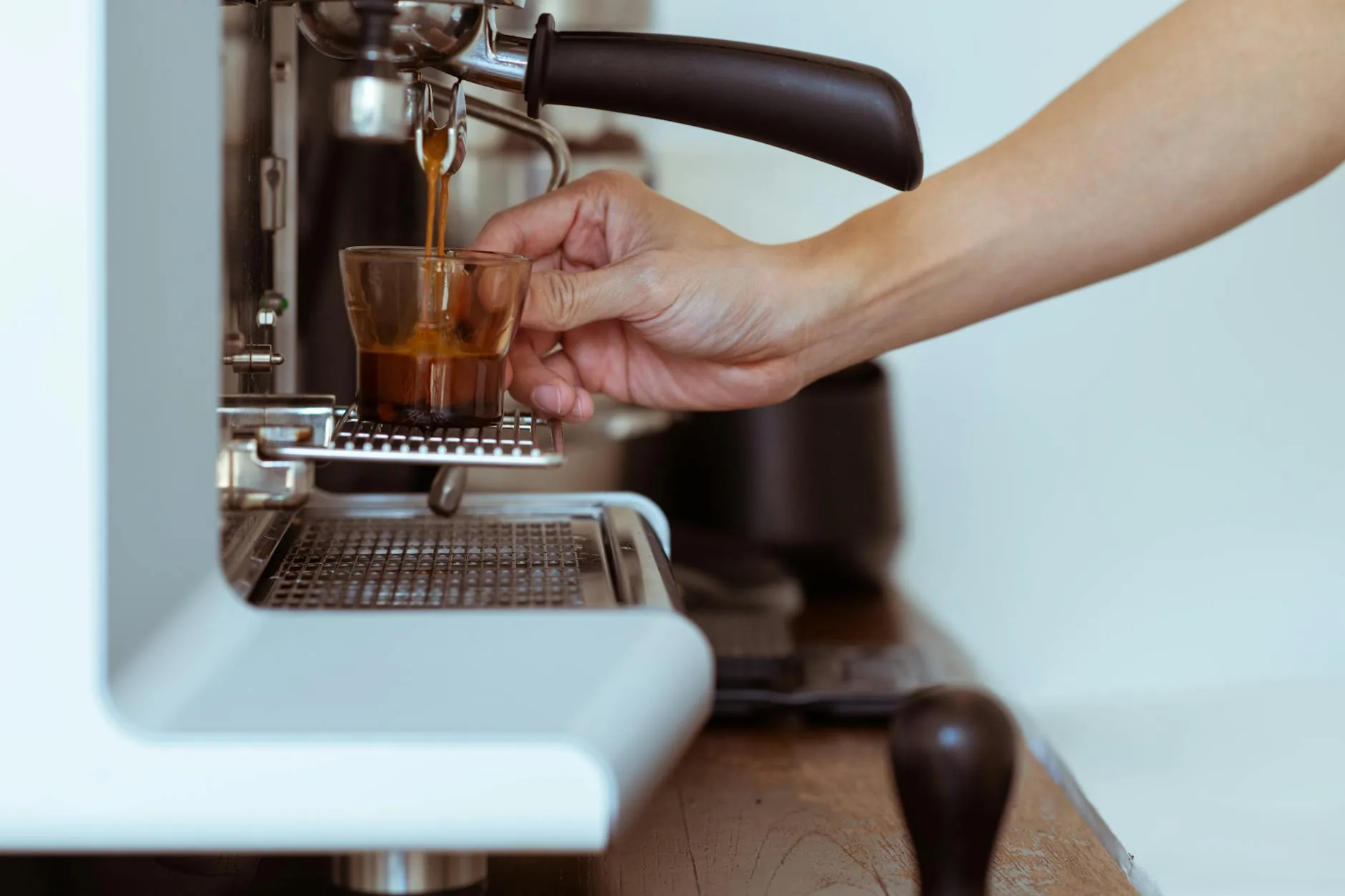 Pouring a fresh espresso shot with crema from a pod coffee machine