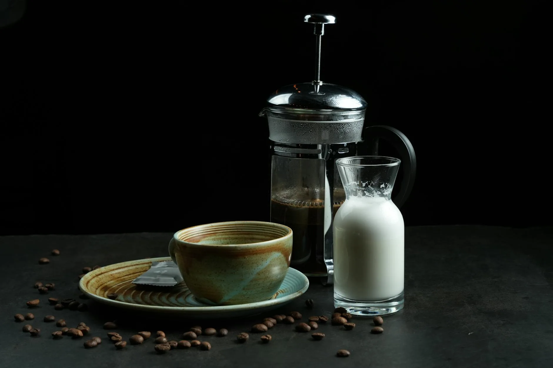 French press with coffee and milk jug on a counter