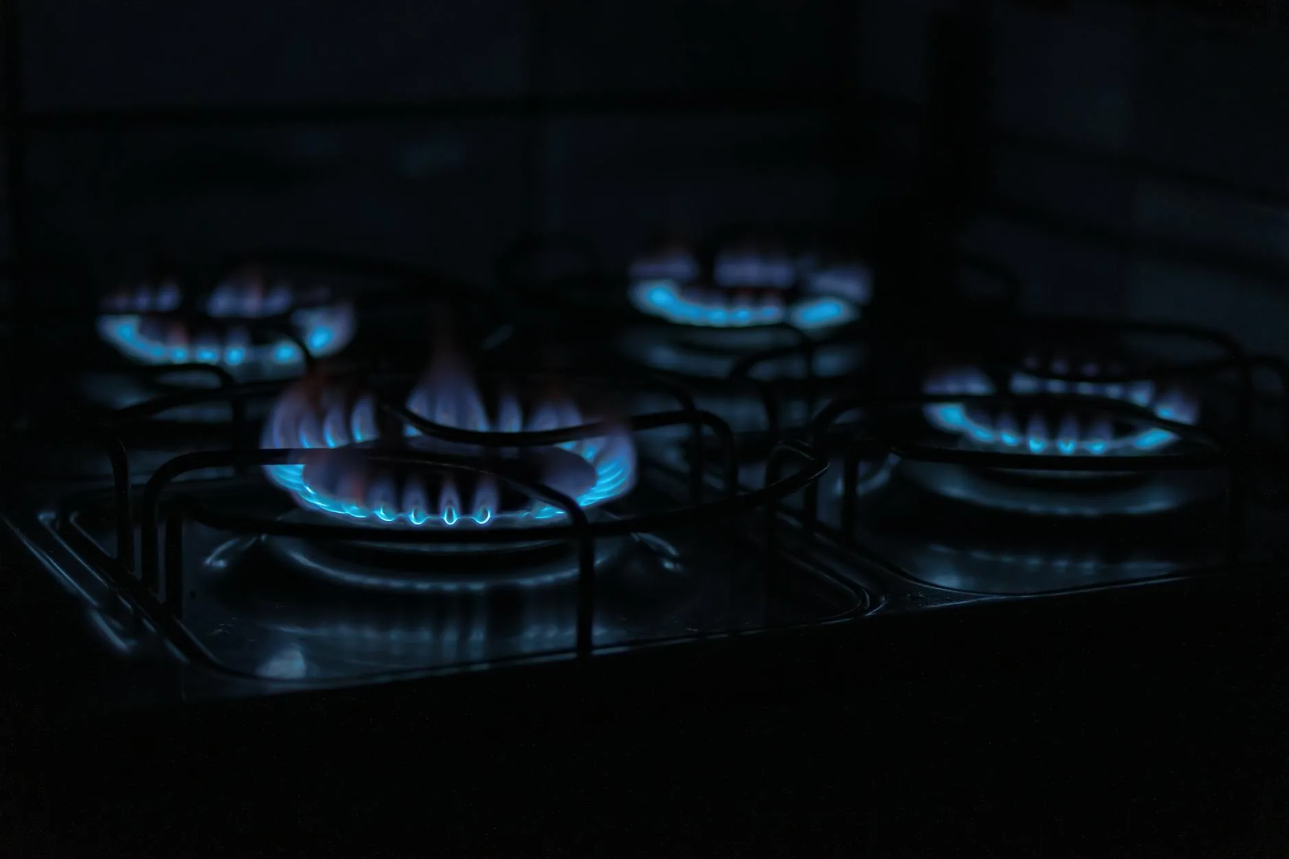 Gas hob with blue flame heating a pan