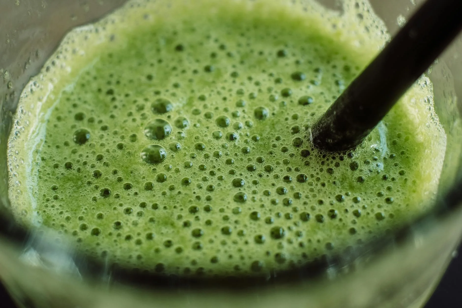 Green smoothie in a glass made with spinach and fresh fruit