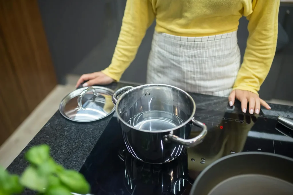 Pan cooking on a modern induction hob in a kitchen