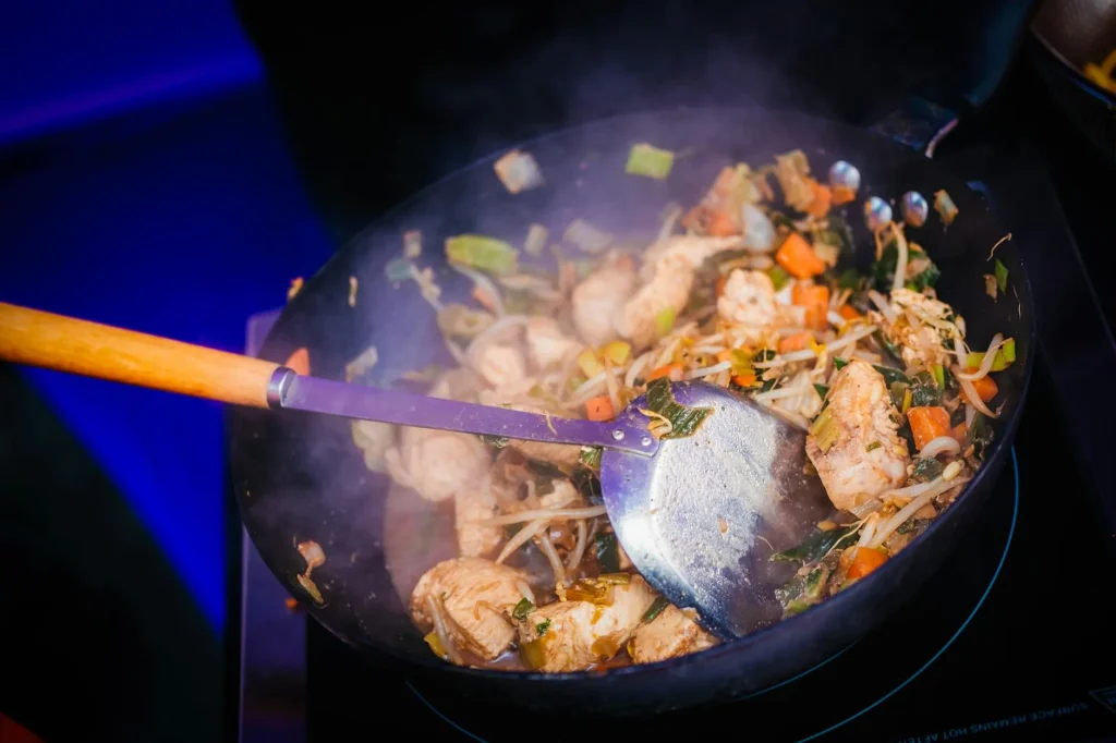 Wok stir-fry cooking over a flame with fresh vegetables