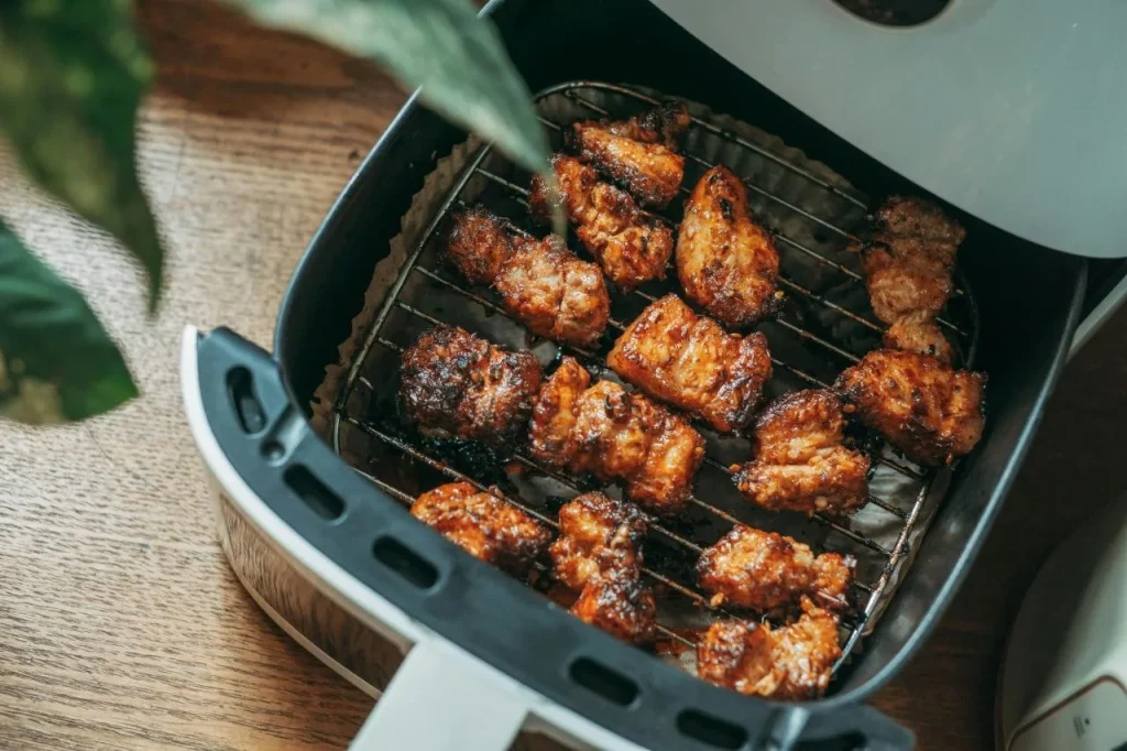 Crispy chicken pieces in an air fryer oven basket