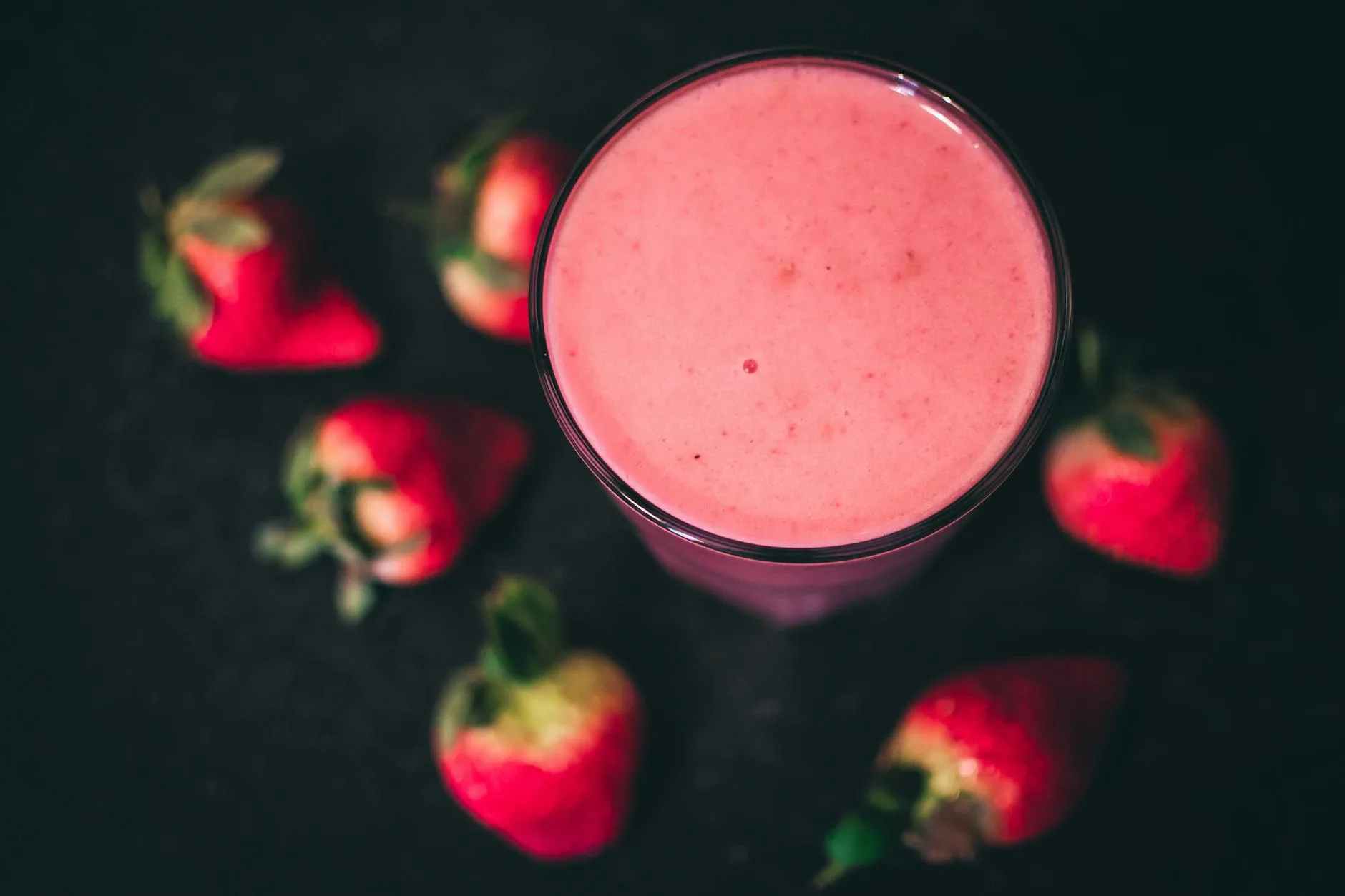 Fresh berry smoothie in a glass with fruit on the side