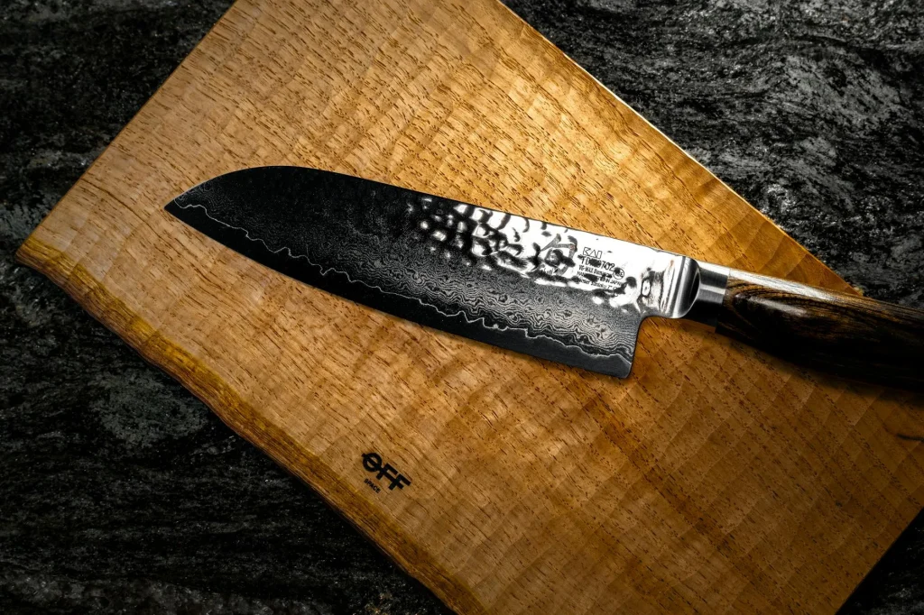 Sharp kitchen knife on a wooden chopping board