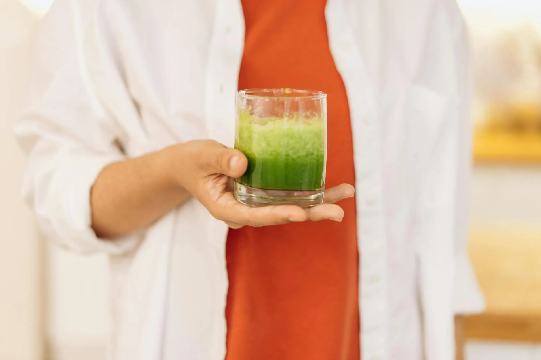 Fresh green juice from a slow juicer in a glass with celery