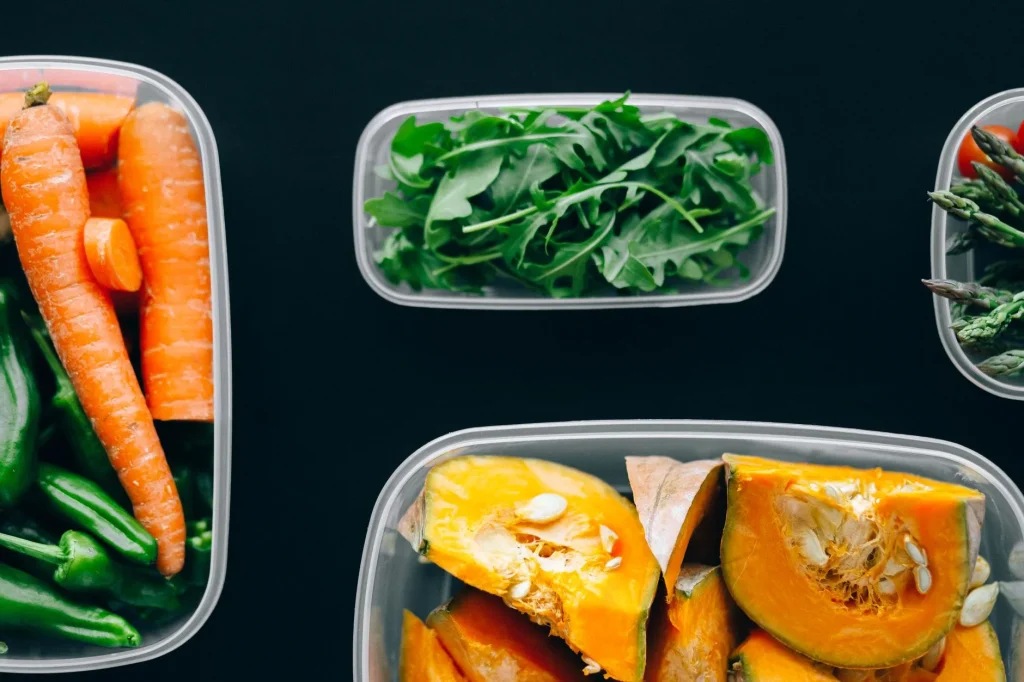 Meal prep containers and chopped vegetables on a kitchen counter