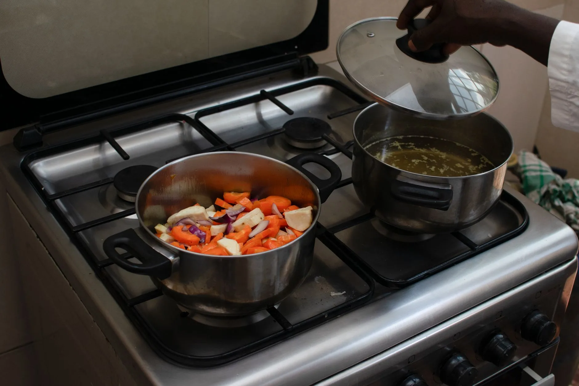 Vegetables cooking in a lidded pot on a kitchen hob